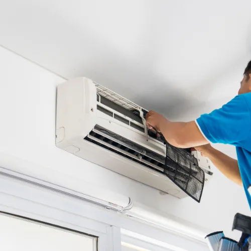 A picture of someone working on a a electrical air conditioning unit