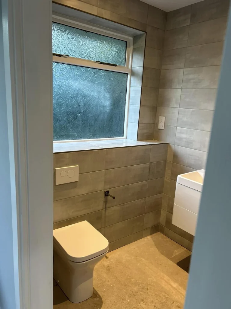 Picture of a tiled bathroom with fitted toilet