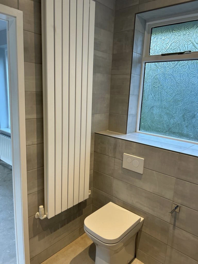 Picture of bathroom fitted after renovation with radiator and toilet