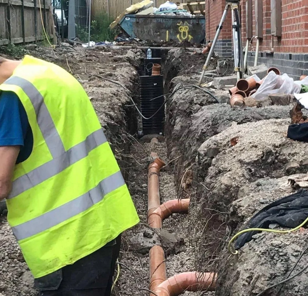 Picture of a man laying out a pipe installation